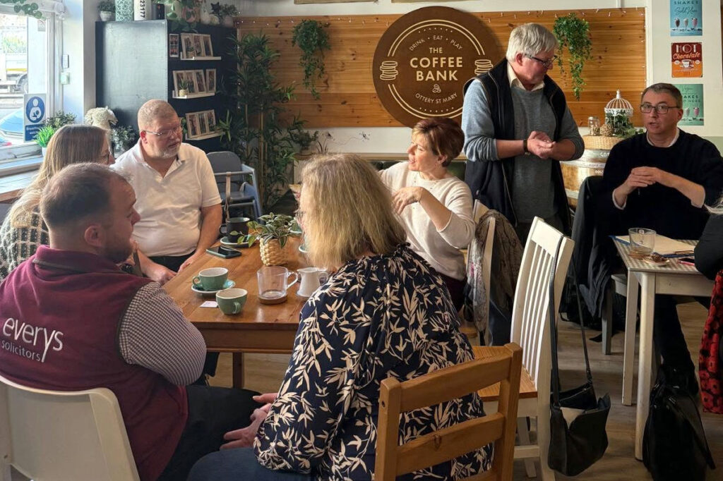 Members of the Ottery Business Network sitting around tables and chatting at The Coffee Bank cafe.